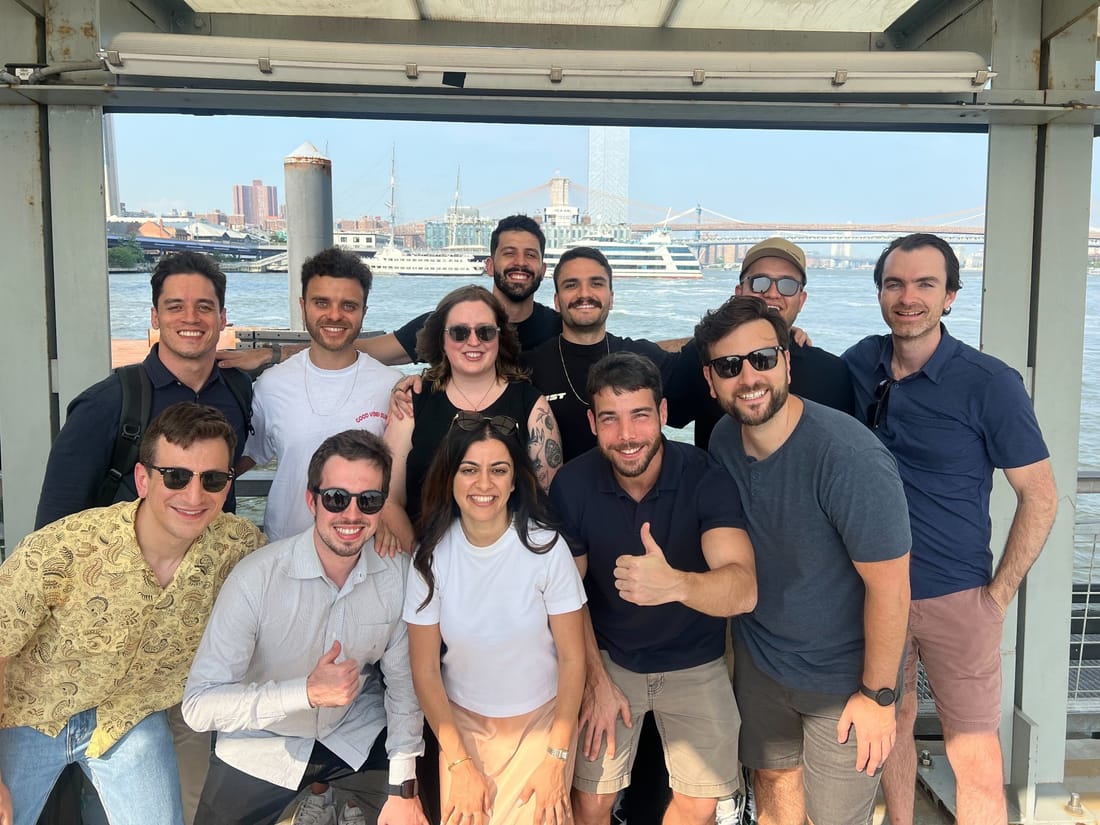 The team on a boat with the New York City skyline behind